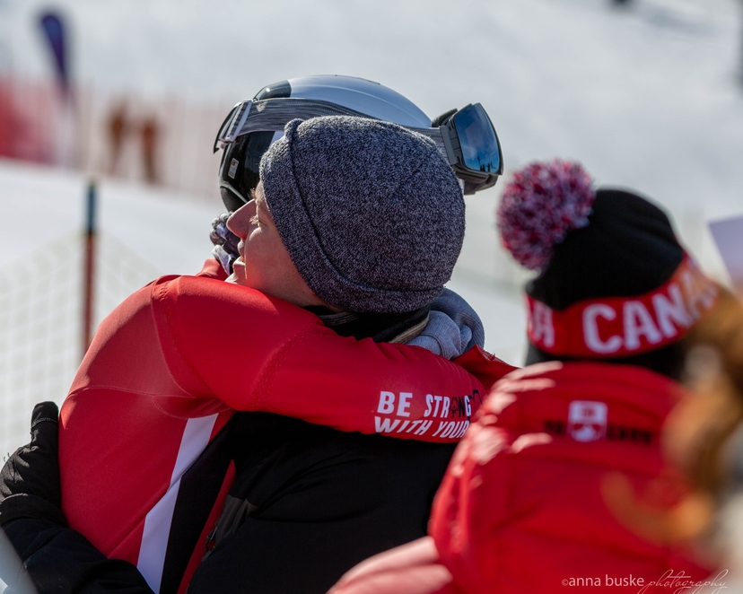 A Skier Hugging Their Coach Or Guardian