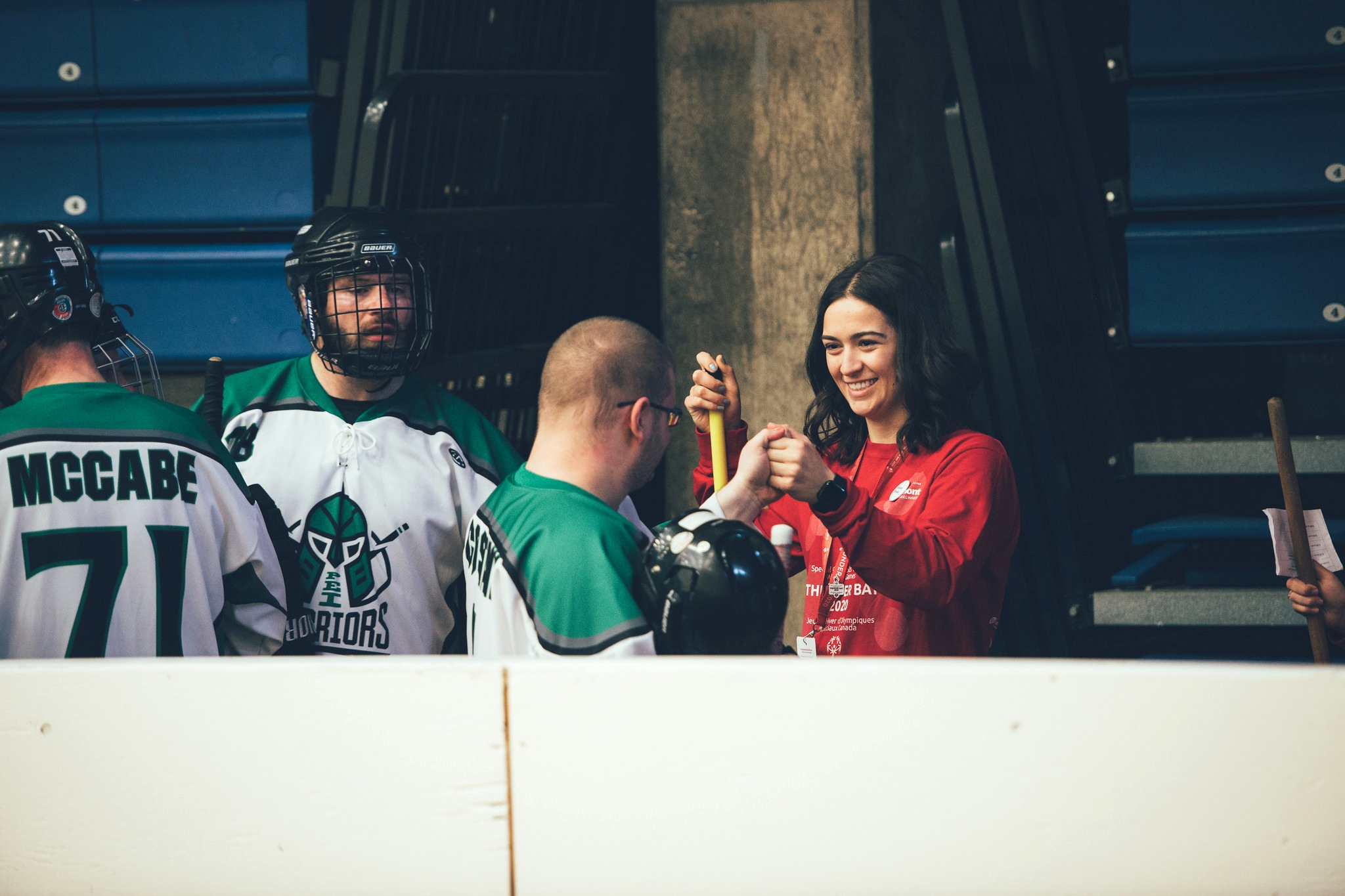 A volounter cheering with two hockey players
